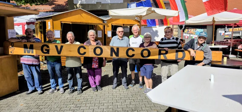 Helferinnen und Helfer hinter dem Stand mit dem Schriftzug MGV Concordia beim Ganzhornfest